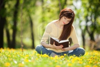 joven-mujer-leyendo-un-libro-en-el-parque-con-flores